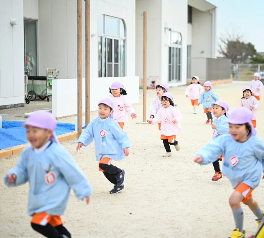 子供達が園庭で楽しく遊んでいる様子