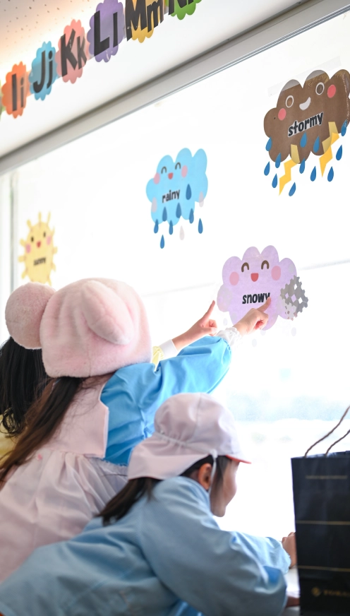 子どもたちが窓に向かって遊んでいる画像
